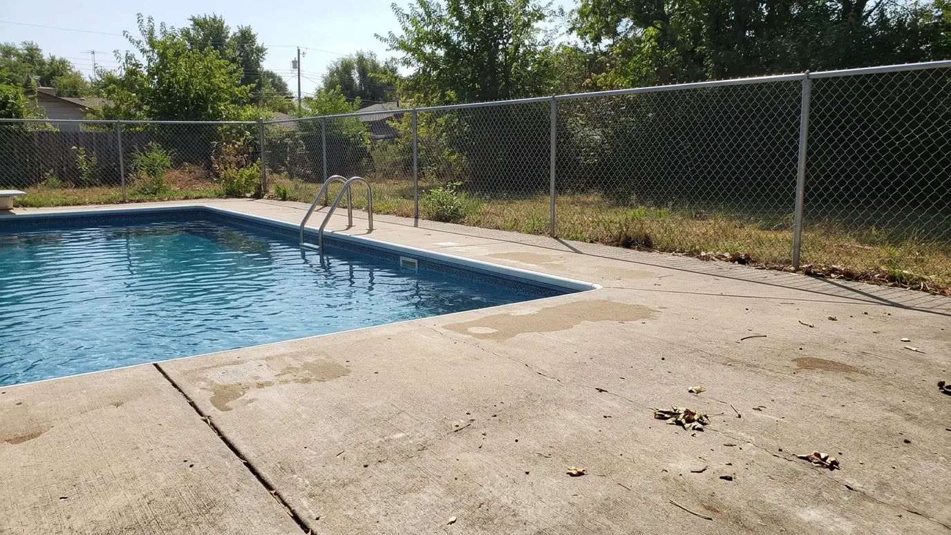 Before: a swimming pool with a pool with a plain poured concrete edge
